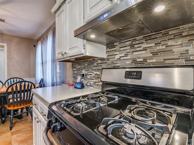124 Canterbury Ct, Bartlesville, OK 74006 - kitchen featuring gas range, under cabinet range hood, backsplash, white cabinets, and light countertops