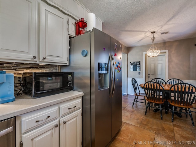 124 Canterbury Ct, Bartlesville, OK 74006 - kitchen with stainless steel appliances, white cabinetry, a textured ceiling, light countertops, and tasteful backsplash
