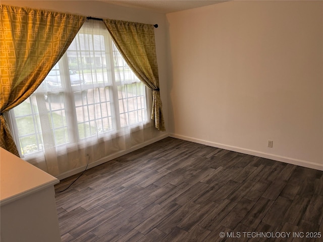 823 Sooner Park Dr, Bartlesville, OK 74006 - empty room featuring dark wood-type flooring and baseboards