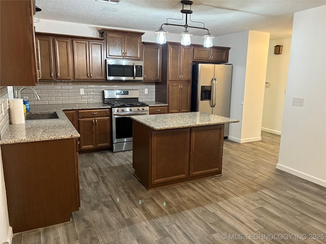 823 Sooner Park Dr, Bartlesville, OK 74006 - kitchen featuring stainless steel appliances, a sink, baseboards, backsplash, and dark wood-style floors