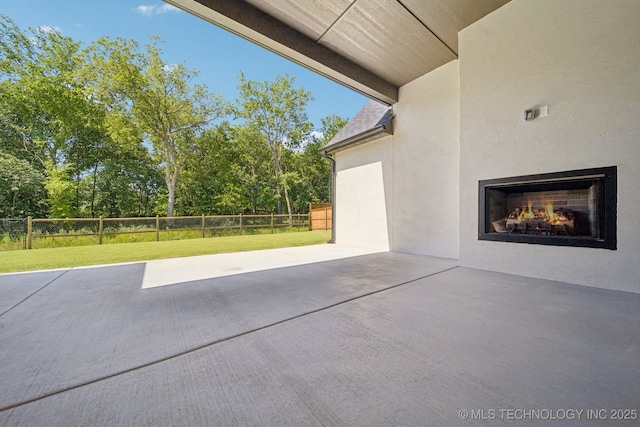 682 W 113th Ct S, Jenks, OK 74037 - fenced backyard with a warm lit fireplace, a patio area, and view of wooded area