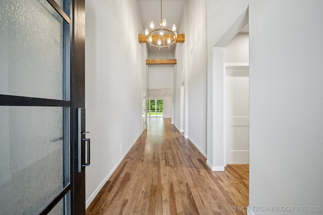 682 W 113th Ct S, Jenks, OK 74037 - hall featuring a chandelier, wood finished floors, and a towering ceiling