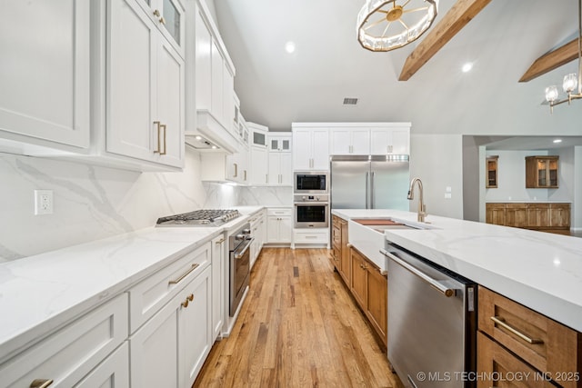 682 W 113th Ct S, Jenks, OK 74037 - kitchen with built in appliances, white cabinetry, glass insert cabinets, and light stone counters