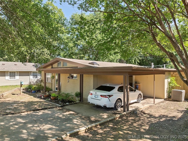 532 Hammers Rd, Ardmore, OK 73401 - view of front facade with concrete driveway, brick siding, an attached carport, and central AC