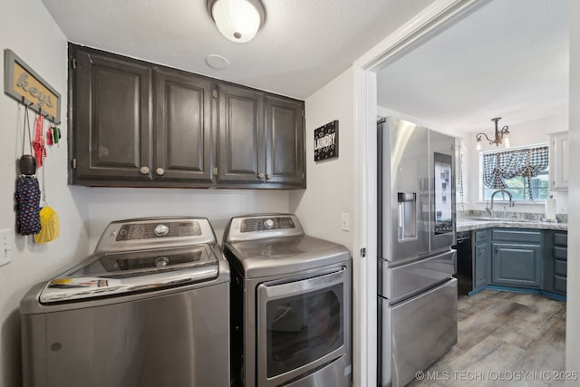 27108 E 82nd St S, Broken Arrow, OK 74014 - laundry room with separate washer and dryer, cabinet space, light wood-style flooring, and a chandelier