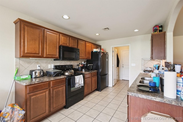 14507 E 110th Pl, Owasso, OK 74055 - kitchen with black appliances, decorative backsplash, light tile patterned flooring, brown cabinetry, and recessed lighting