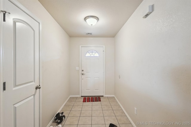 14507 E 110th Pl, Owasso, OK 74055 - doorway with light tile patterned floors and baseboards