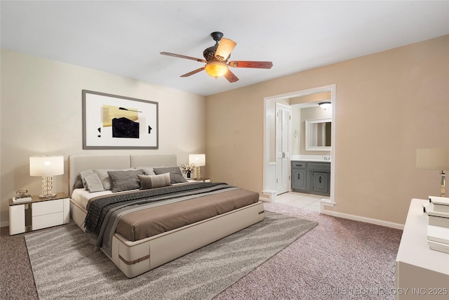 carpeted bedroom featuring baseboards, ensuite bath, and ceiling fan