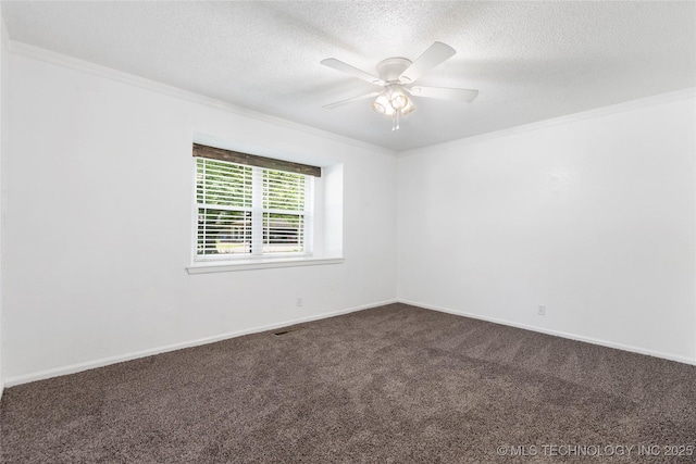 spare room with dark colored carpet, crown molding, a textured ceiling, a ceiling fan, and baseboards