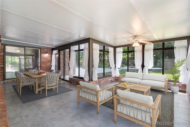 sunroom / solarium featuring brick wall