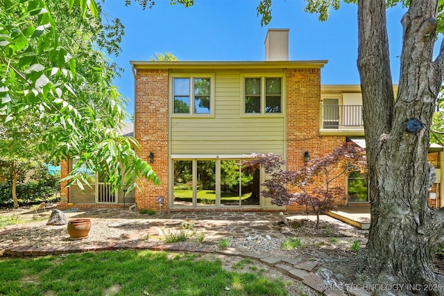 3805 E 64th Pl, Tulsa, OK 74136 - back of house featuring a patio, a chimney, a balcony, and brick siding