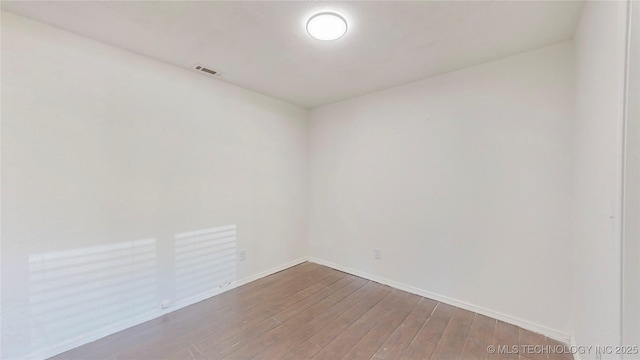 empty room with wood finished floors and baseboards
