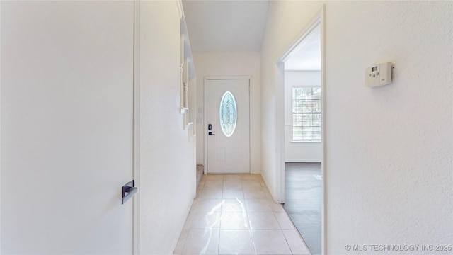 doorway with light tile patterned flooring