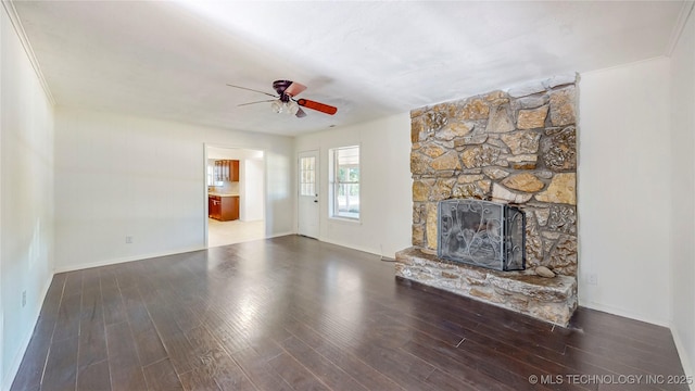 unfurnished living room with a ceiling fan, a fireplace, wood finished floors, and baseboards