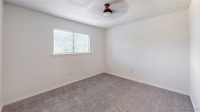 carpeted empty room with ceiling fan and baseboards