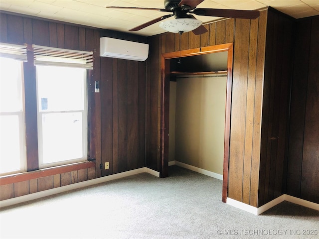 509 N Michigan Ave, Cushing, OK 74023 - unfurnished bedroom featuring a wall mounted air conditioner, wooden walls, carpet floors, a closet, and baseboards
