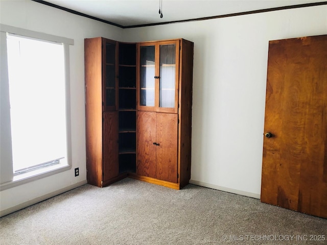 509 N Michigan Ave, Cushing, OK 74023 - unfurnished bedroom with light colored carpet, baseboards, and crown molding