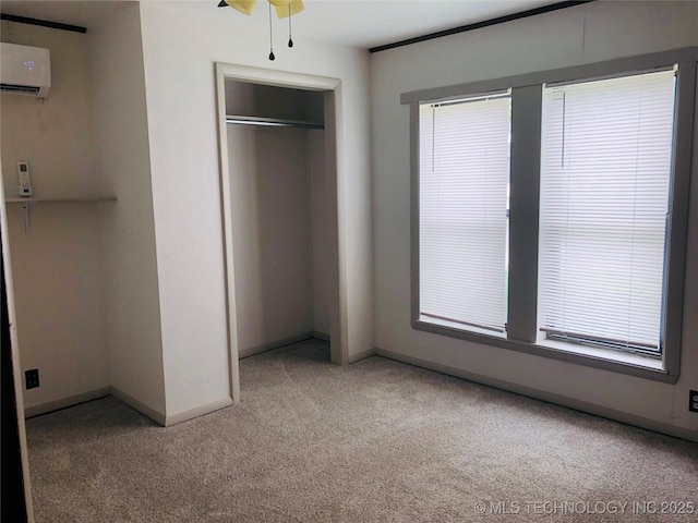 509 N Michigan Ave, Cushing, OK 74023 - unfurnished bedroom featuring light colored carpet, a wall mounted air conditioner, baseboards, and a closet
