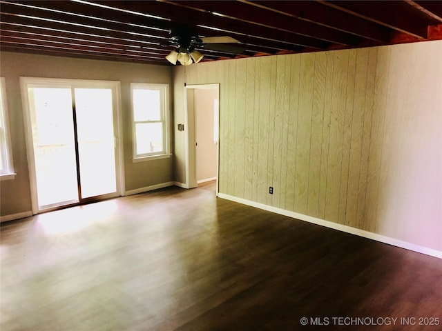 509 N Michigan Ave, Cushing, OK 74023 - unfurnished room with a ceiling fan, wooden walls, wood finished floors, and baseboards