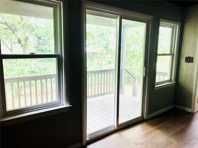 509 N Michigan Ave, Cushing, OK 74023 - doorway to outside featuring dark wood-style flooring and baseboards