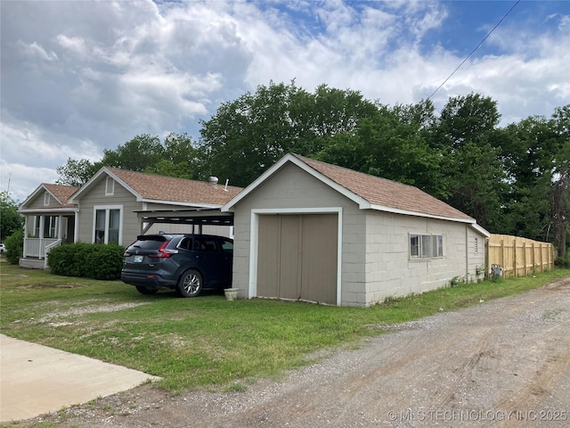 509 N Michigan Ave, Cushing, OK 74023 - detached garage featuring driveway, a carport, and a storage unit