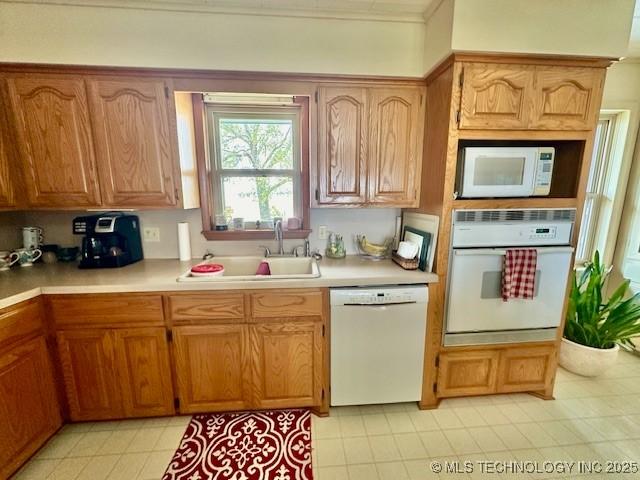 27414 S 4440th Rd, Vinita, OK 74301 - kitchen featuring white appliances, a sink, light countertops, light tile patterned floors, and crown molding