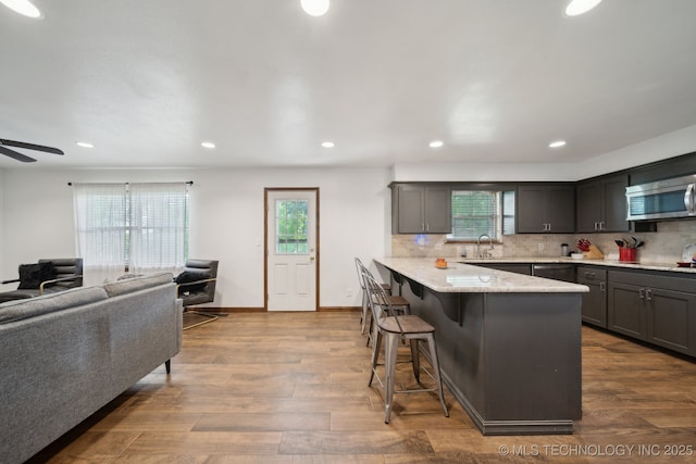 215 Rodman Cir, Muskogee, OK 74403 - kitchen featuring a peninsula, a breakfast bar area, a sink, healthy amount of natural light, and recessed lighting