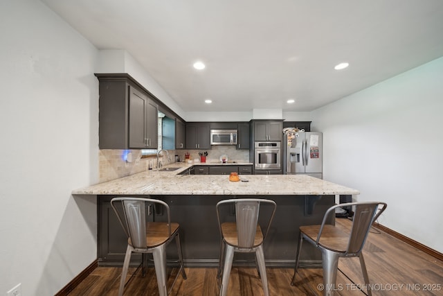 215 Rodman Cir, Muskogee, OK 74403 - kitchen featuring appliances with stainless steel finishes, a sink, baseboards, light stone counters, and decorative backsplash