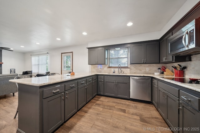 215 Rodman Cir, Muskogee, OK 74403 - kitchen with stainless steel appliances, a sink, a peninsula, tasteful backsplash, and a breakfast bar