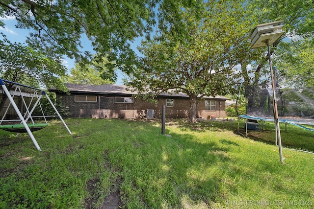 215 Rodman Cir, Muskogee, OK 74403 - view of green lawn with a trampoline, a playground, and central AC unit