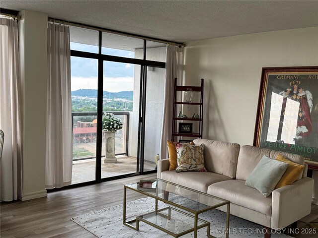 410 W 7th St Unit 1722, Tulsa, OK 74119 - living area with floor to ceiling windows, wood finished floors, a textured ceiling, and a mountain view