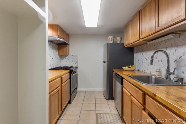 410 W 7th St Unit 1722, Tulsa, OK 74119 - kitchen with black range with gas stovetop, butcher block countertops, exhaust hood, and backsplash