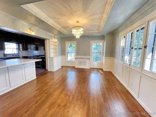 525 W Downing St, Tahlequah, OK 74464 - kitchen featuring ornamental molding, hardwood / wood-style floors, a chandelier, a raised ceiling, and light countertops