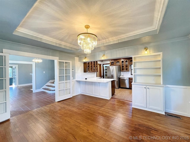 525 W Downing St, Tahlequah, OK 74464 - kitchen featuring a chandelier, stainless steel appliances, a raised ceiling, and crown molding