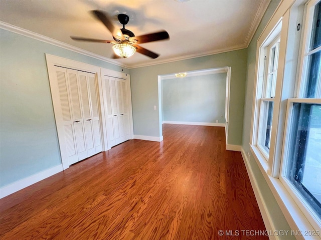 525 W Downing St, Tahlequah, OK 74464 - unfurnished bedroom with multiple closets, ornamental molding, wood finished floors, ceiling fan, and baseboards