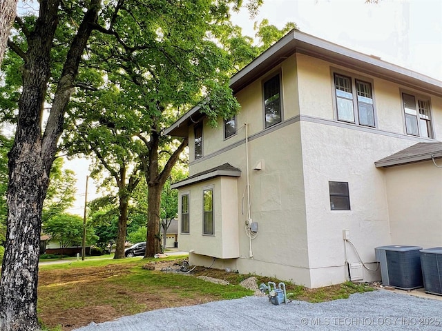 525 W Downing St, Tahlequah, OK 74464 - view of home's exterior with stucco siding and central AC unit