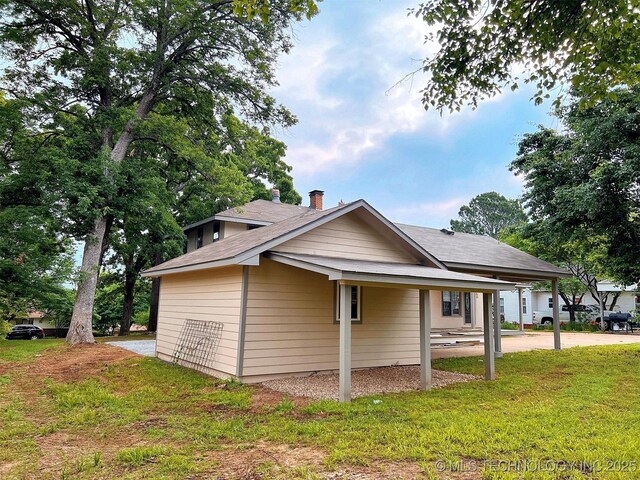 525 W Downing St, Tahlequah, OK 74464 - view of home's exterior featuring a lawn and a carport