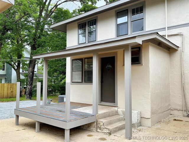 525 W Downing St, Tahlequah, OK 74464 - doorway to property with stucco siding, fence, and a deck