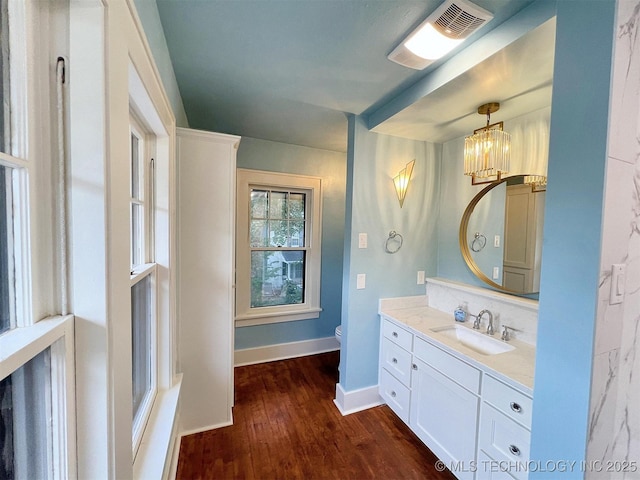 525 W Downing St, Tahlequah, OK 74464 - bathroom with toilet, vanity, baseboards, wood finished floors, and a chandelier