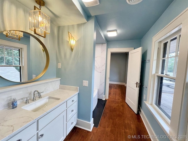 525 W Downing St, Tahlequah, OK 74464 - bathroom featuring a chandelier, wood finished floors, vanity, and baseboards