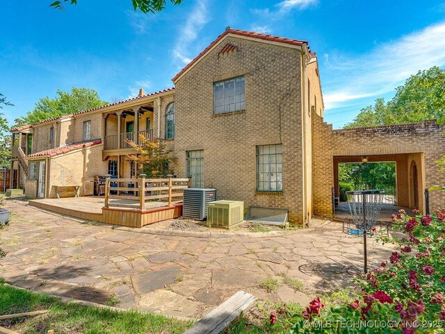 back of house with a patio, cooling unit, a deck, a balcony, and a tiled roof
