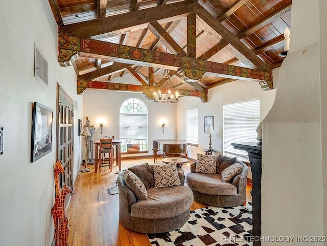 living room featuring beamed ceiling, a chandelier, wooden ceiling, wood finished floors, and high vaulted ceiling