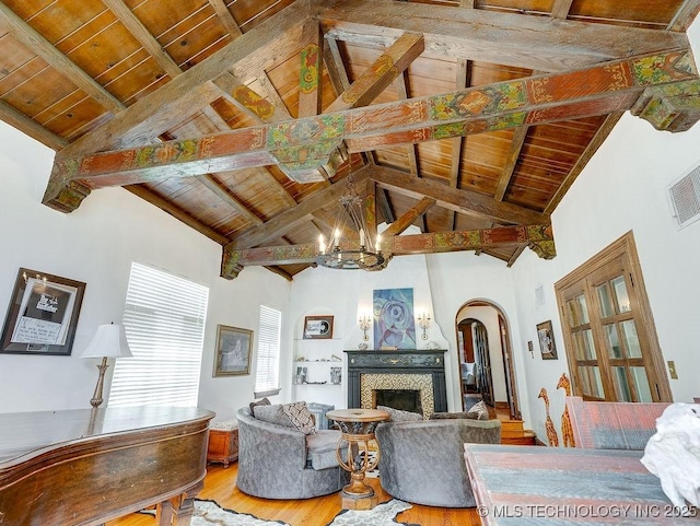 living area featuring wood ceiling, a chandelier, arched walkways, wood finished floors, and beam ceiling