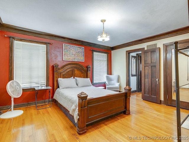 bedroom featuring light wood-style floors, baseboards, and ornamental molding