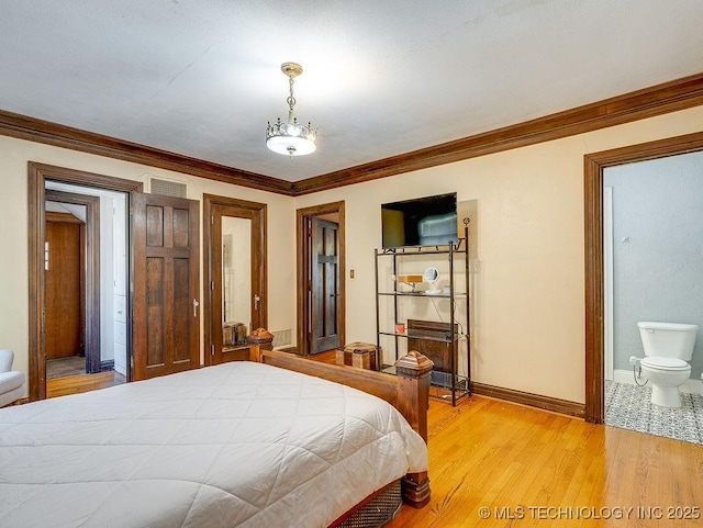 bedroom with ornamental molding, light wood-style floors, baseboards, and ensuite bathroom