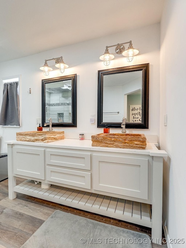 bathroom with double vanity and wood finished floors