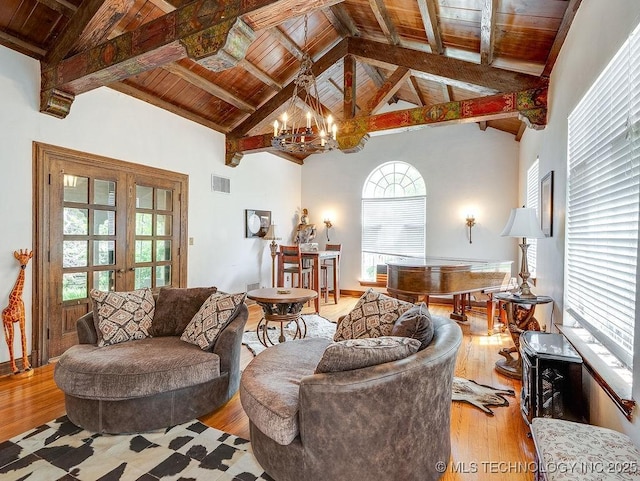 living room with wooden ceiling, a chandelier, light wood finished floors, beamed ceiling, and high vaulted ceiling