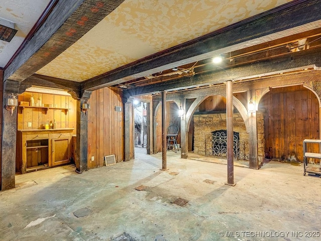 below grade area featuring wooden walls and a fireplace