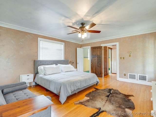bedroom featuring light wood-style floors, crown molding, and a ceiling fan