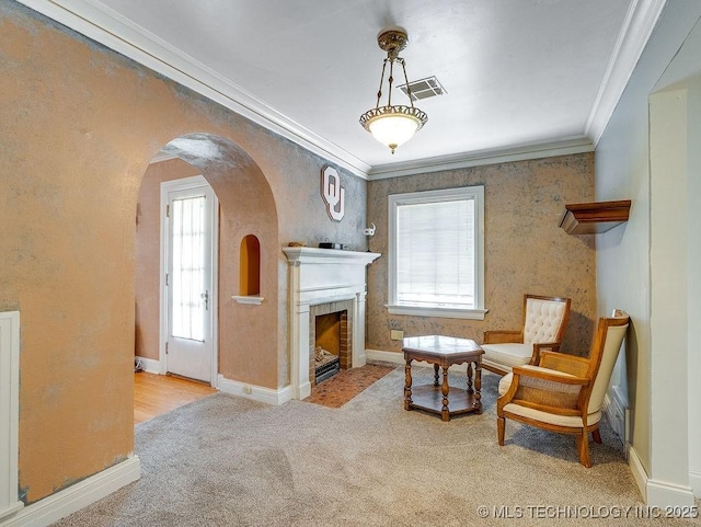 sitting room featuring ornamental molding, carpet, plenty of natural light, baseboards, and arched walkways